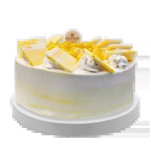 Elegant white frosted cake with yellow ribbon bow, cake slices, and a decorative gold-topped topper on display