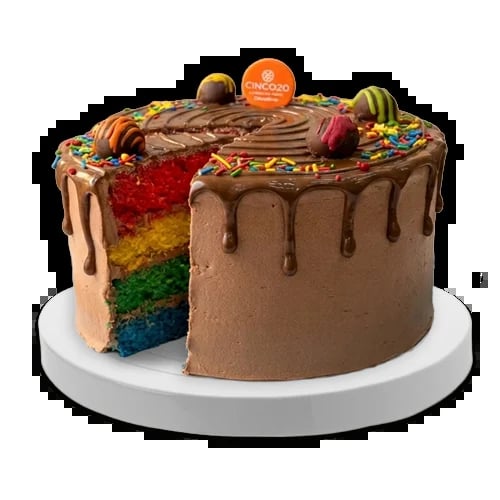 Rainbow layer cake with chocolate frosting, candy toppings, and drip glaze on white cake board