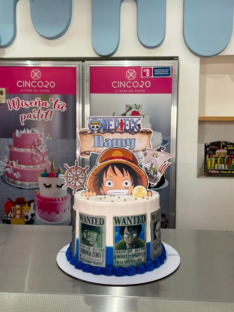 One Piece themed cake with Luffy character topper and wanted posters on white base with blue trim