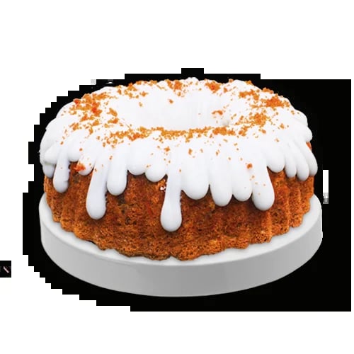 Round spice cake with white dripping glaze and cinnamon crumble topping on white plate